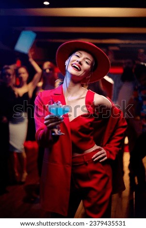 Party and celebration. Happy smiling young woman drinking cocktail having fun at the night club
