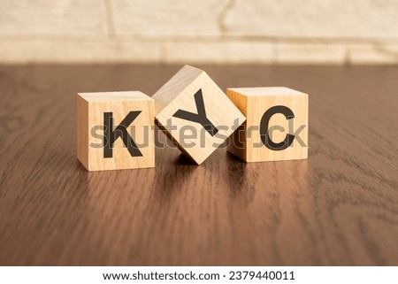 Know Your Client concept with symbols KYC on wooden cubes, dark wooden background