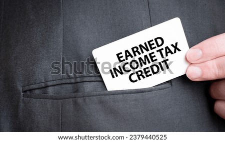 Card with EARNED INCOME TAX CREDIT text in pocket of businessman suit. Investment and decisions business concept.