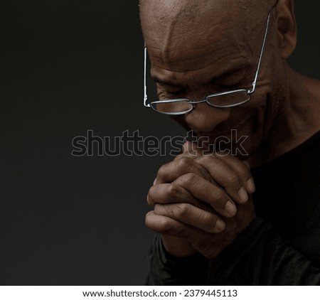 black man praying to god on gray black background with people stock image stock photo