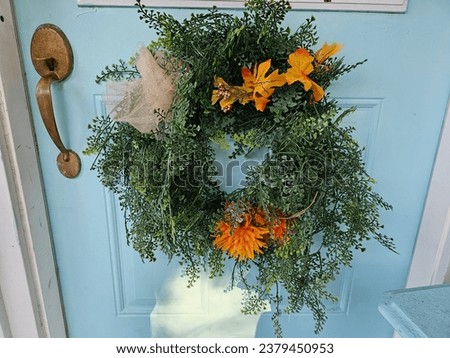 A large wreath hanging on a front door.