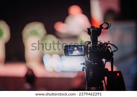 Dark podcast talk show with red neon lights from behind the camera Royalty-Free Stock Photo #2379462291