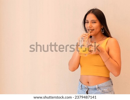 Beautiful young woman drinking orange juice Royalty-Free Stock Photo #2379487141