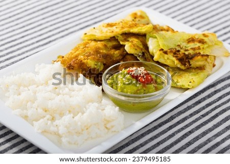 Homemade breaded cabbage leaves with spicy tomato sauce and guacamole