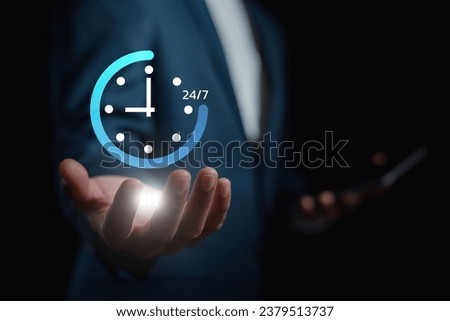 nonstop service concept. businessman hand holding virtual 24-7 with clock on hand for smart phone nonstop and full-time available contact of service concept. customer service. Royalty-Free Stock Photo #2379513737