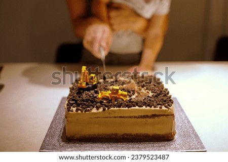 Midsection of mother and son cutting birthday cake Royalty-Free Stock Photo #2379523487