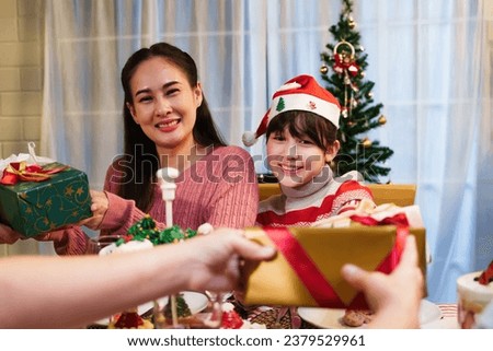 Portrait of asian happy family celebration in christmas day, sitting the dining room at home. look at camera ready to celebrate merry xmas and happy new year.