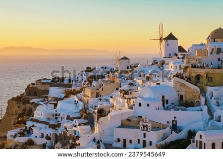 sunset by the ocean of Oia Santorini Greece, a traditional Greek village in Santorini with whitewashed churches and blue domes during summer Royalty-Free Stock Photo #2379545649