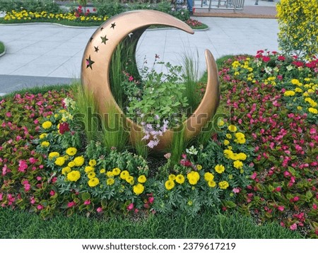 A stunning image of vibrant flowers in a beautiful garden alongside a crescent-shaped structure. It symbolizes the blend of nature and art, creating a dreamlike scene under the moonlight, captivating 