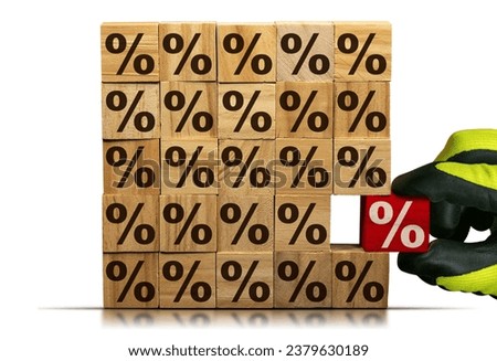 Gloved hand chooses a wooden block with red percentage sign, from a stack of wooden blocks with brown percent signs. Isolated on white background.