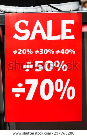 Red sale sign made of paper promoting large discounts.