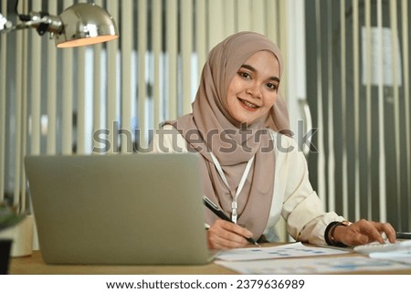 Successful business woman in hijab using laptop working on marketing projects at modern office.