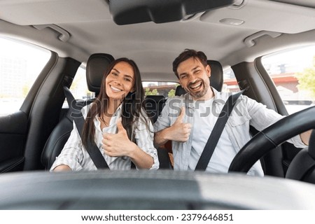 Happy cheerful millennial couple showing high five and smiling at camera, young excited man and woman enjoying car ride, having adventure at weekend, traveling together