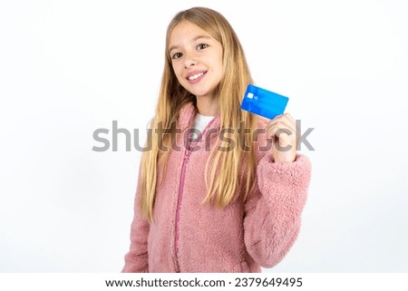 Close up photo of optimistic  beautiful caucasian kid girl hold card