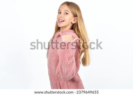 Impressed beautiful caucasian kid girl point back empty space