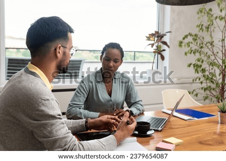 Two young freelance business people, staff meeting, analysing and advisory at modern office. Business partners, small company owners, working on new project. Brainstorming concept Royalty-Free Stock Photo #2379654087