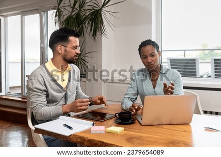 Two young freelance business people, staff meeting, analysing and advisory at modern office. Business partners, small company owners, working on new project. Brainstorming concept Royalty-Free Stock Photo #2379654089