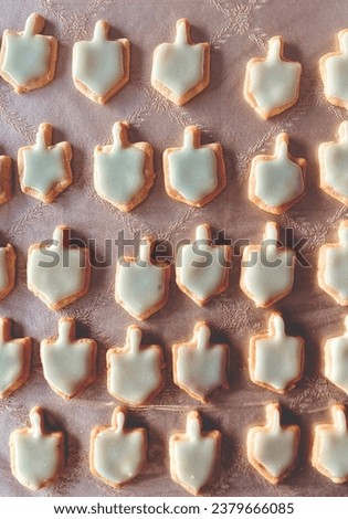 Dreidel shaped sugar cookies coated in frosting.- Chanukah themed cookies.