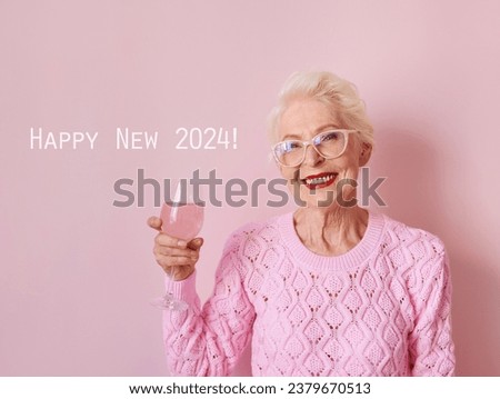 happy caucasian senior woman in cashmere pink sweater drinking rose on pink background. Celebrating, love, retirement, mature concept  Royalty-Free Stock Photo #2379670513