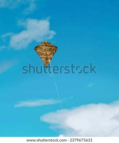 Kaghati kites are flying against the backdrop of a clear blue sky. Kaghati is a traditional kite from the people of Muna, Southeast Sulawesi.