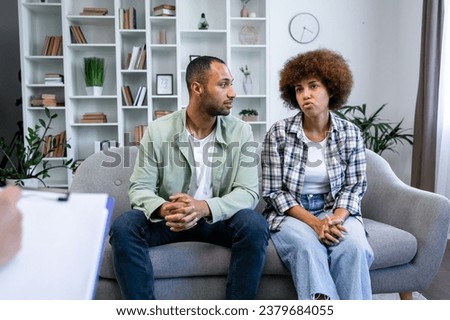 Couple therapy. Nice serious pleasant couple visiting a psychologist and having a psychological session while dealing with problems in relationships