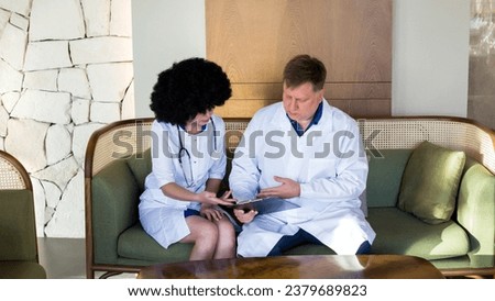 A couple of doctors talking hall, discussing the diagnosis of a patient.