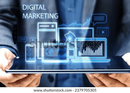 Close up of man hand holding pad with creative blue gadgets and business chart hologram on blurry pixel background. Digital marketing, finance, social network and online service concept