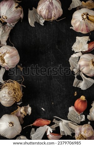 Fresh garlic bulbs and cloves grouped on black background. Flat lay. Top view. Food concept. Dark mood food photography.