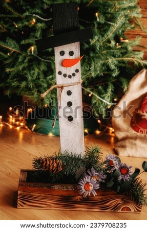Wooden handmade Christmas decoration in the form of a snowman (selective focus)
