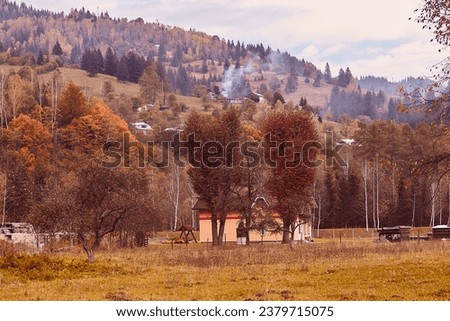 Autumn rustic background, atmospheric ukrainian village with houses on the hills.