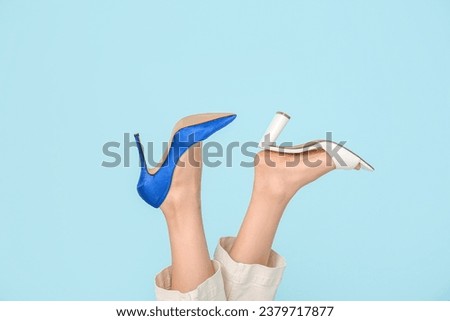 Female legs in different high heeled shoes on color background Royalty-Free Stock Photo #2379717877