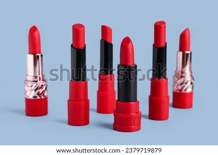 Set of red lipsticks on color background