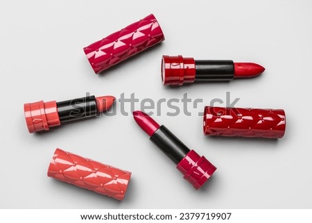 Different stylish lipsticks on light background