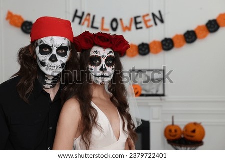 Couple in scary bride and pirate costumes indoors, space for text. Halloween celebration