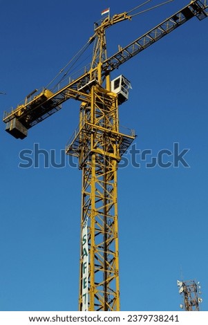 A yellow crane being operated by the operator at a construction site
