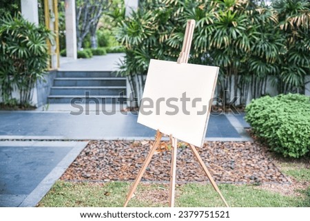 Empty white board canvas on wooden easel in the garden, Welcome sign, Mock up about wedding event 