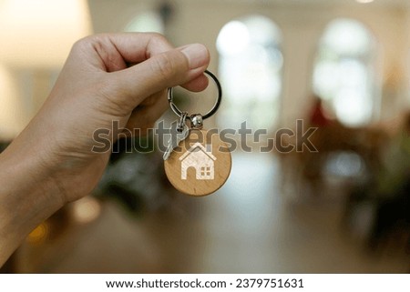 Hand holding the key of a house, Real estate agent, rental, ownership concept.