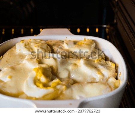 Potatoes pie baked in electric oven. Potato gratin in baking dish inside an oven. Shepherd's pie, traditional British dish with minced meat and mashed potato Royalty-Free Stock Photo #2379762723
