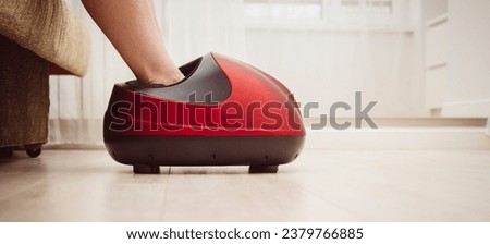 the girl does a massage with an electric foot massager. High quality photo