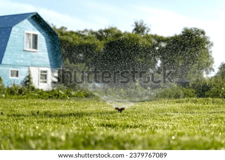 automatic lawn watering waters the lawn in front of the house. High quality photo
