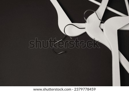 White wooden clothes hangers on black background. Sale and shopping concept. Black Friday. copy space