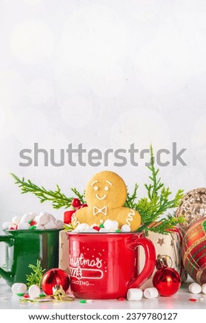 Funny cute gingerbread man in a hot chocolate, cappuccino or latte. Festive Christmas cocoa mug with marshmallow and cookie, with Christmas tree, decor, on white bokeh background copy space  