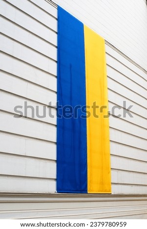 Ukrainian flag on a white building wall as a sign of solidarity with Ukraine