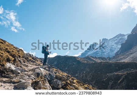 Young hiker backpacker man enjoying valley view in Makalu Barun Park route near Khare during high altitude acclimatization walk. Mera peak trekking route, Nepal. Active vacation concept image Royalty-Free Stock Photo #2379808943