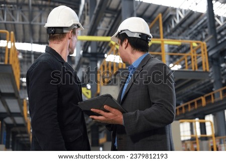 A couple of businessman work out at the sideline of an electric train garage