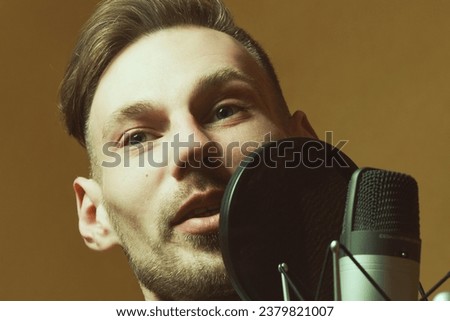 Radio dj concept. Portrait of handsome young man with blond hair hosting show live in studio. Trendy haircut. Close up. Indoor shot