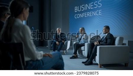 International Business Conference: Caucasian Female Tech CEO Talking With Male Host In Front Of Audience Of Diverse Attendees. Successful Woman Delivering Inspirational Speech For Women In Leadership.