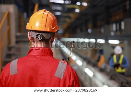 Portrait back view of technician with red safety uniform and orange hard hat Industrial and technology Royalty-Free Stock Photo #2379828169