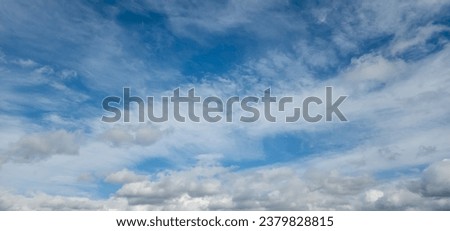 In this close-up photo, cumulus and stratus clouds dance across the sky, their shapes intricate and distinct. Cotton tufts of cumulus clouds intertwine with stratus, smooth expanses of stratus clouds Royalty-Free Stock Photo #2379828815