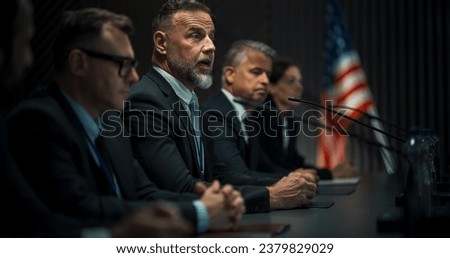 Caucasian Male Organization Representative Speaking at Economic Forum. Head Of USA Delegation Delivering Speech at International Political Summit Press Conference. Diverse Delegates Listening. Royalty-Free Stock Photo #2379829029